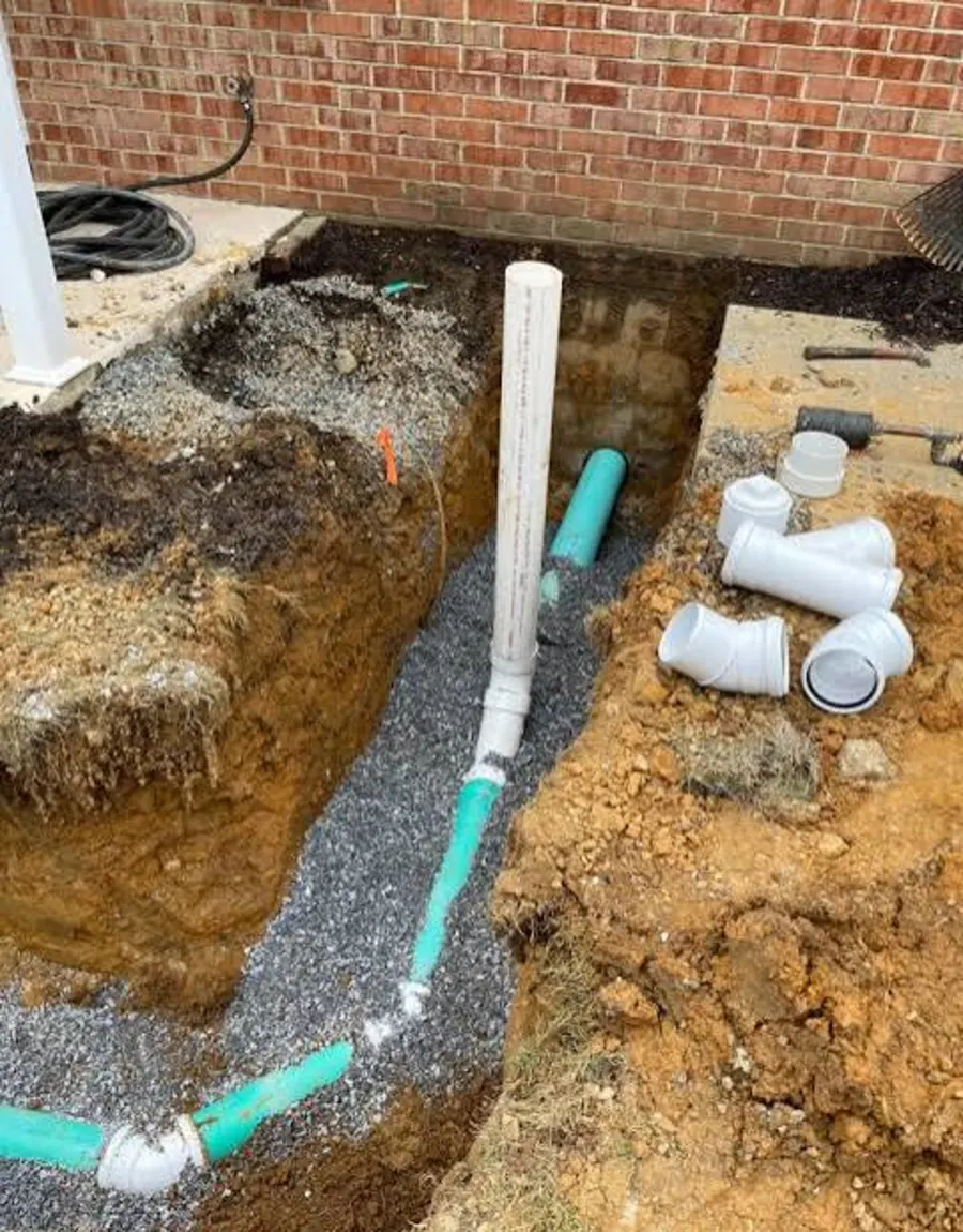 Open trench with new sewer pipe and fittings ready to set